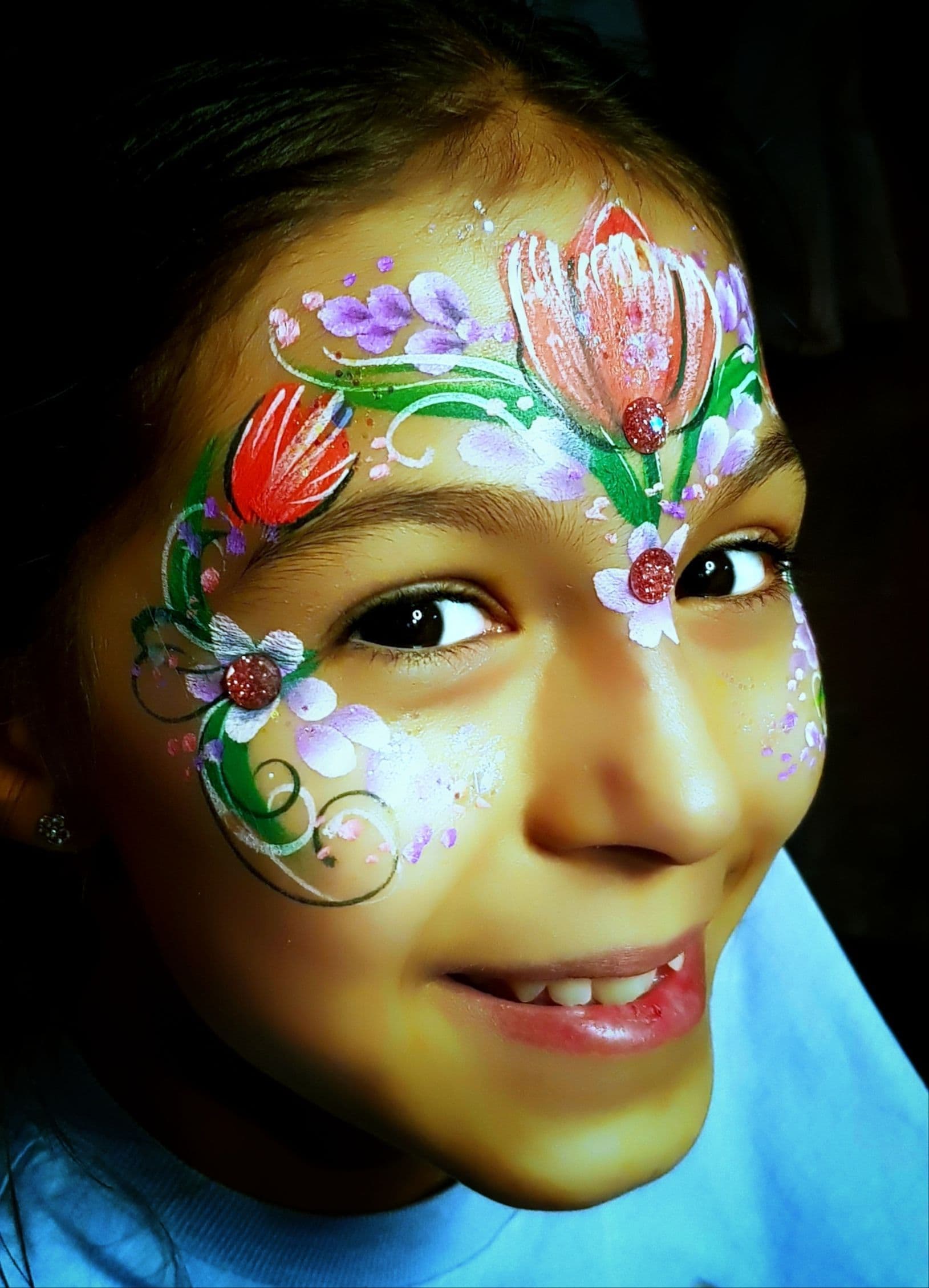 A child smiling with her face painted.