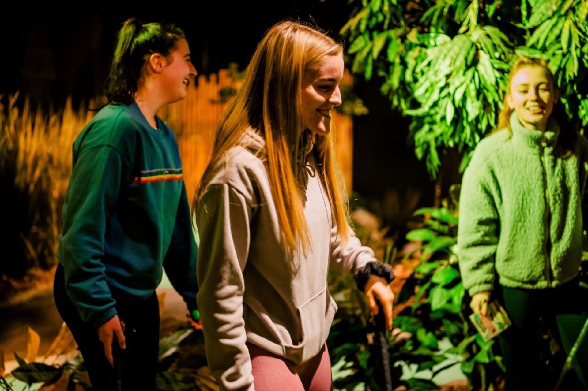 Teenagers At Treetop Smiling While Playing Golf
