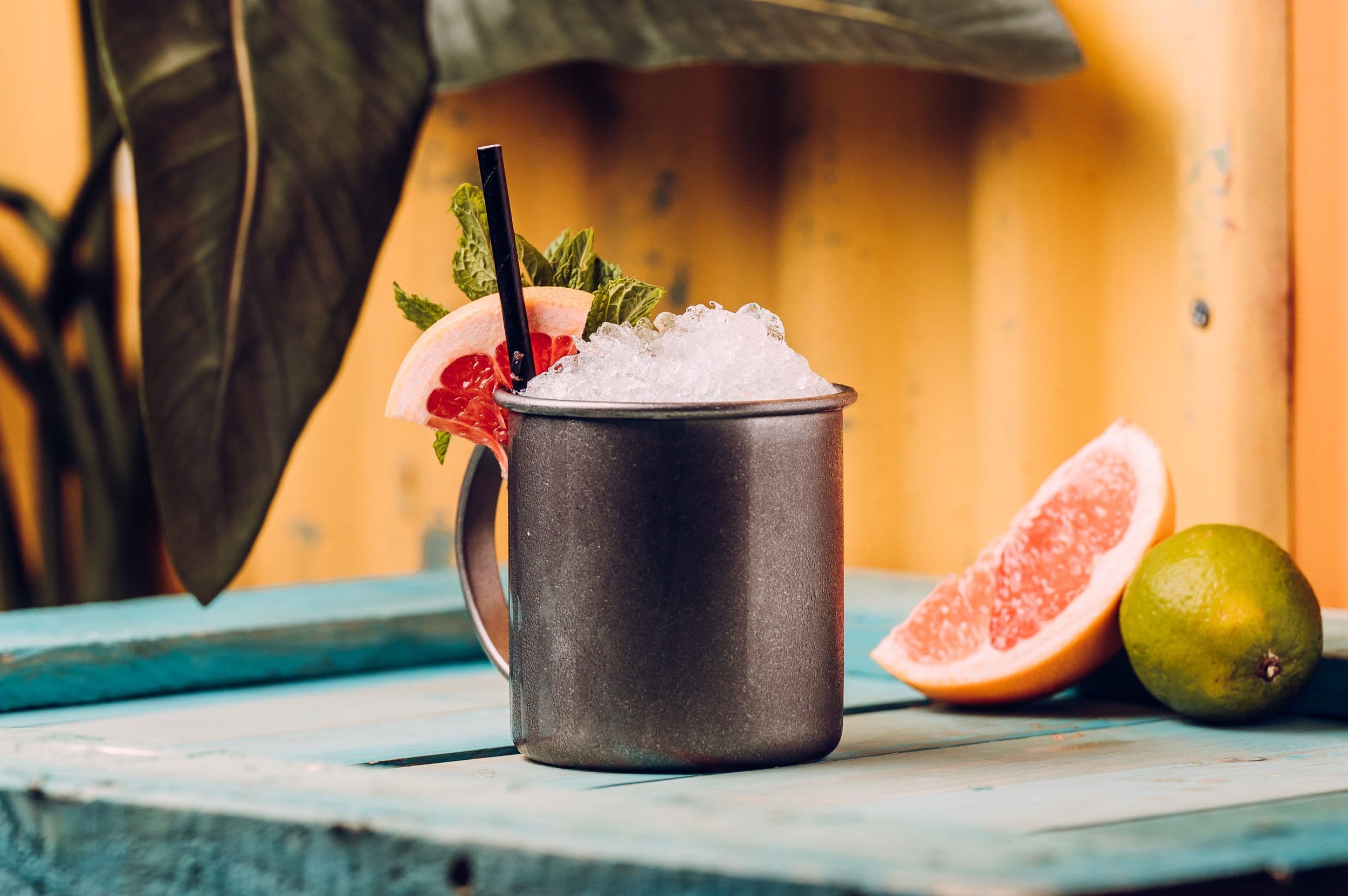 A summer cocktail with pieces of fruit displayed next to it.